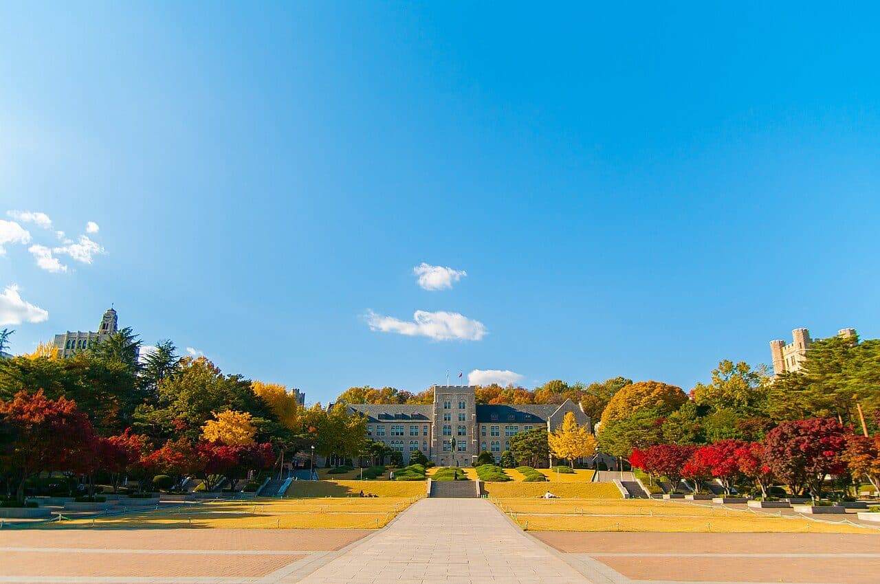 Korea University's main hall in Seoul, framed by autumn trees